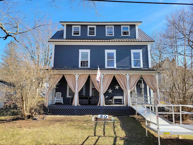 view of front facade with metal roof, a porch, and a front lawn