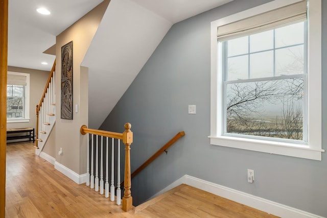 staircase with wood finished floors, baseboards, and recessed lighting