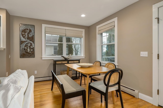dining room with recessed lighting, light wood-style flooring, a baseboard heating unit, and baseboards