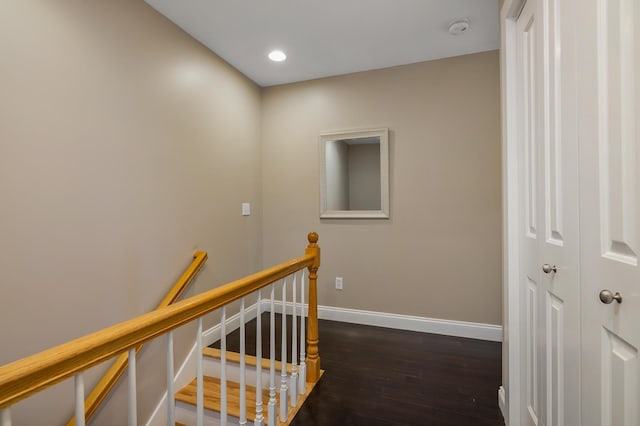 corridor with baseboards, an upstairs landing, recessed lighting, and dark wood-style floors