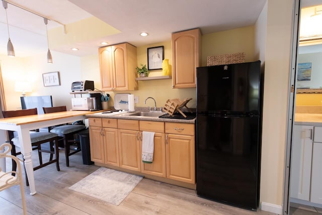 933 Ocean Blvd Unit 107, Hampton, NH 03842 - kitchen with decorative light fixtures, light brown cabinetry, light wood-type flooring, a sink, and freestanding refrigerator