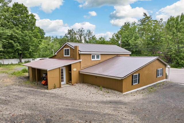 rustic home featuring fence and metal roof