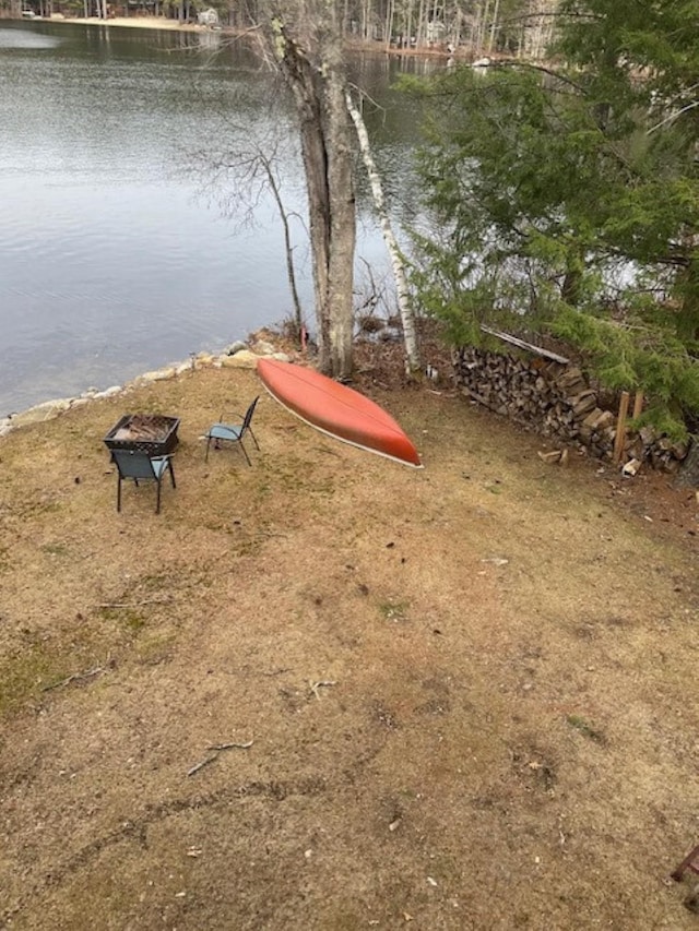 view of yard featuring a water view and an outdoor fire pit