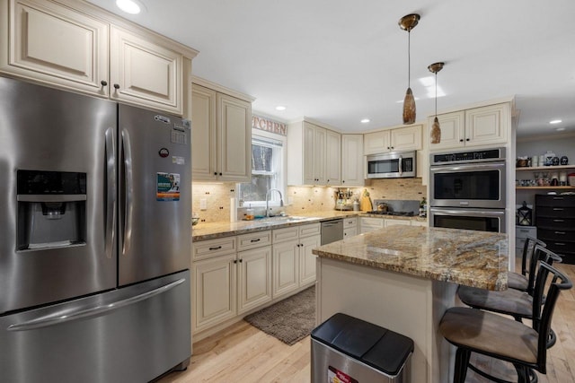 9 Sands Ter, Barnstead, NH 03225 - kitchen featuring cream cabinets, appliances with stainless steel finishes, a sink, light wood-style flooring, and tasteful backsplash