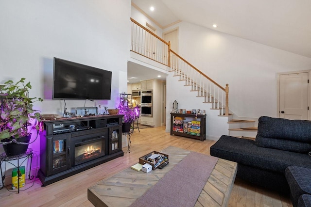 9 Sands Ter, Barnstead, NH 03225 - living area featuring stairway, high vaulted ceiling, light wood-style floors, a glass covered fireplace, and recessed lighting