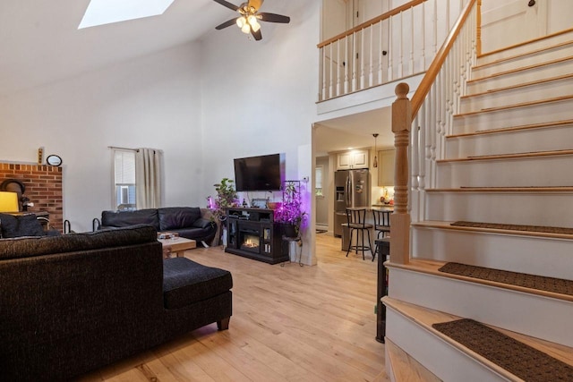 9 Sands Ter, Barnstead, NH 03225 - living room with high vaulted ceiling, a fireplace, stairs, a ceiling fan, and light wood-style flooring