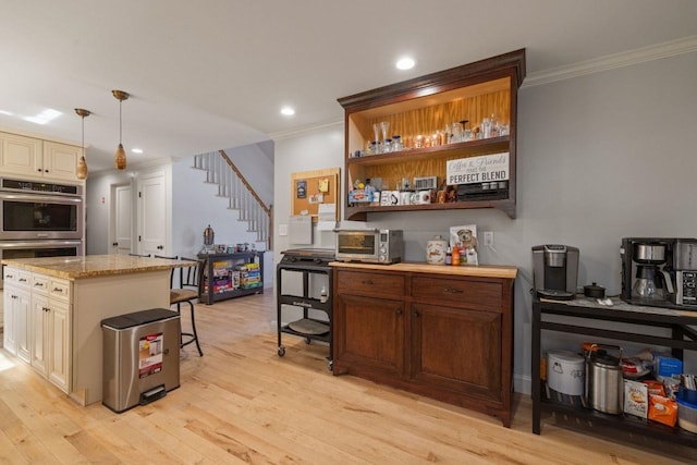 9 Sands Ter, Barnstead, NH 03225 - bar featuring stainless steel double oven, crown molding, light wood-style floors, stairway, and pendant lighting