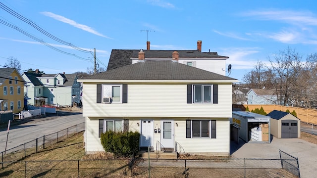 view of front of house with a fenced front yard, driveway, and a shingled roof