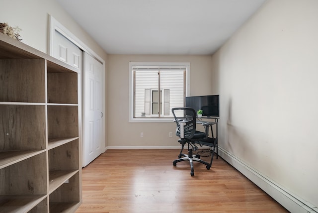 home office featuring light wood-type flooring, baseboards, and a baseboard heating unit
