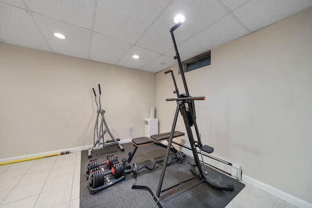 workout area with a drop ceiling, recessed lighting, a baseboard heating unit, and baseboards