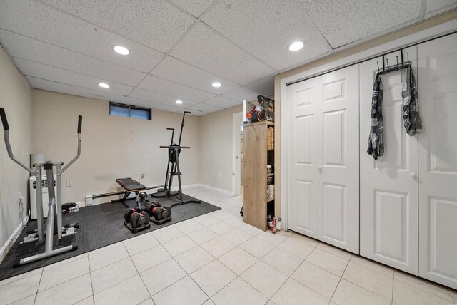 exercise room with recessed lighting, a baseboard radiator, baseboards, and light tile patterned floors