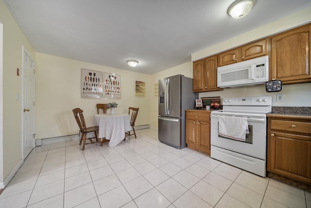 kitchen featuring dark countertops, white appliances, brown cabinetry, light tile patterned floors, and baseboards