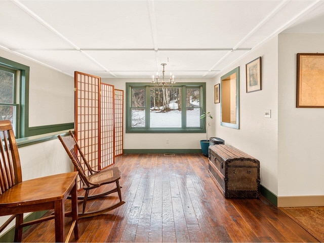 sitting room featuring a chandelier, baseboards, and hardwood / wood-style flooring