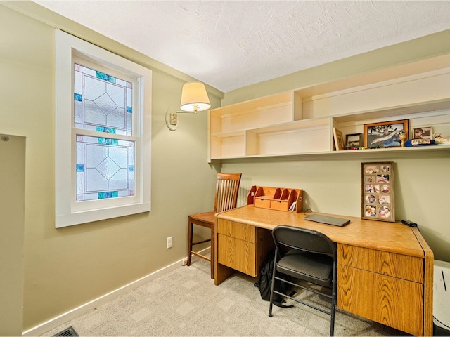 office featuring baseboards, light colored carpet, and a textured ceiling
