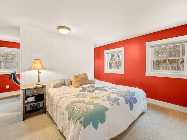 carpeted bedroom featuring multiple windows and baseboards