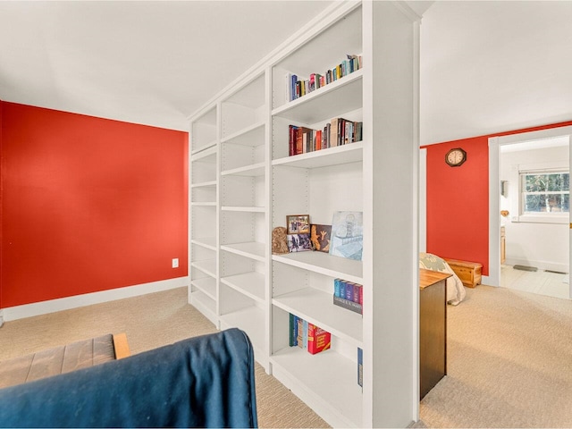 living area with lofted ceiling, carpet, and baseboards