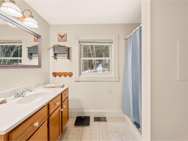 bathroom with vanity, a shower with curtain, visible vents, and baseboards