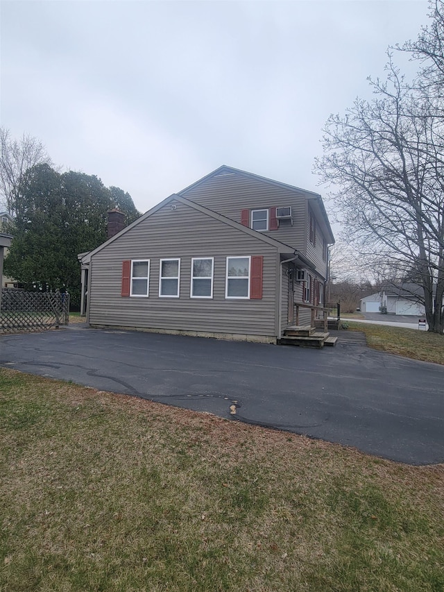 view of property exterior featuring a chimney and a lawn