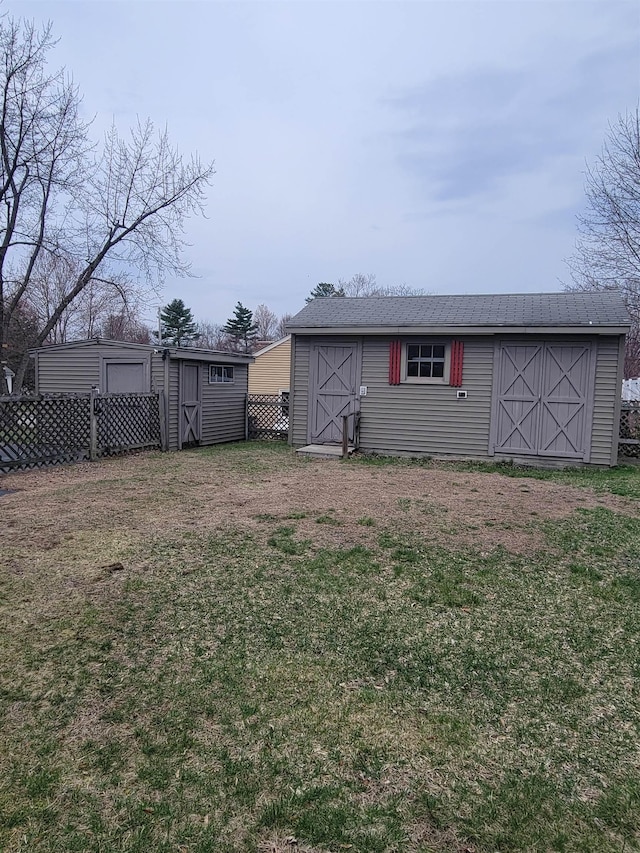 view of yard with fence, an outbuilding, and a storage shed