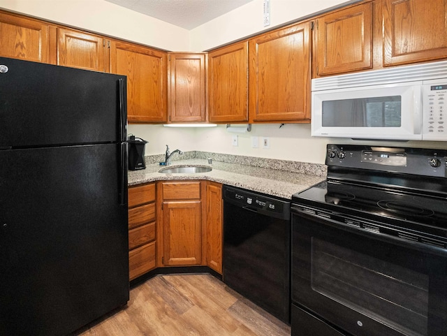 133 E Mountain Rd Unit 3C17, Killington, VT 05751 - kitchen featuring black appliances, light wood-style floors, a sink, and brown cabinetry