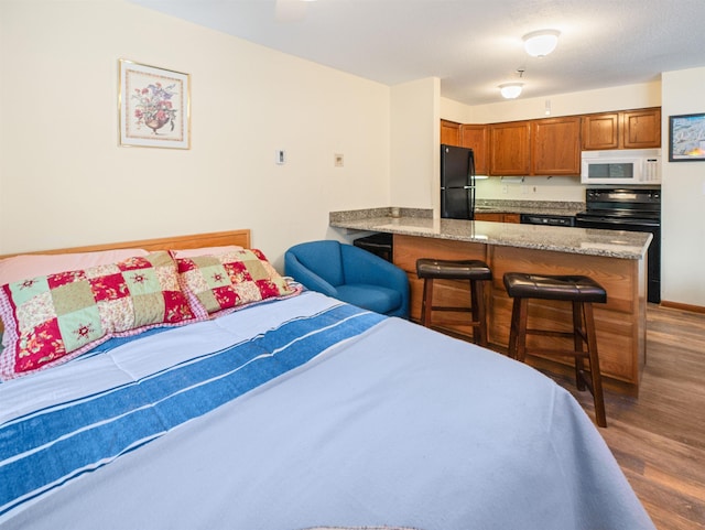 133 E Mountain Rd Unit 3C17, Killington, VT 05751 - bedroom with freestanding refrigerator and wood finished floors