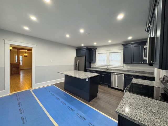 42 Elm St, Claremont, NH 03743 - kitchen with appliances with stainless steel finishes, a center island, plenty of natural light, dark wood-style flooring, and recessed lighting