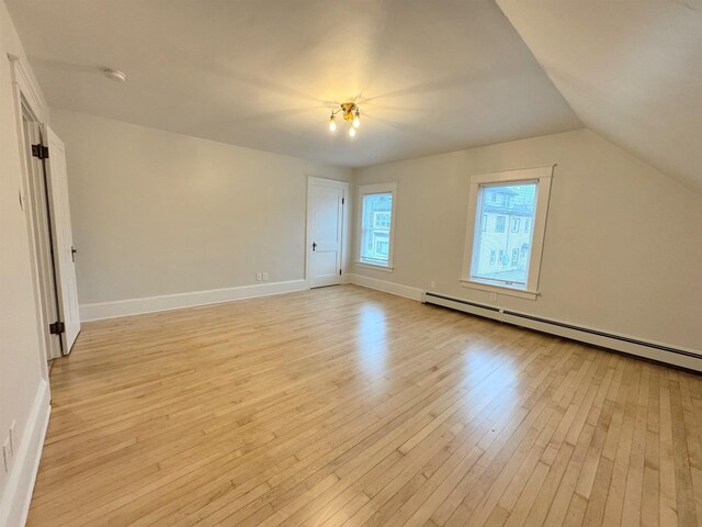 42 Elm St, Claremont, NH 03743 - empty room featuring light wood-style flooring, a baseboard radiator, a smoke detector, and lofted ceiling