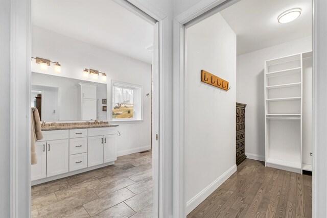 7 John Hardie Way, Chichester, NH 03234 - bathroom featuring baseboards, wood finished floors, double vanity, and a sink