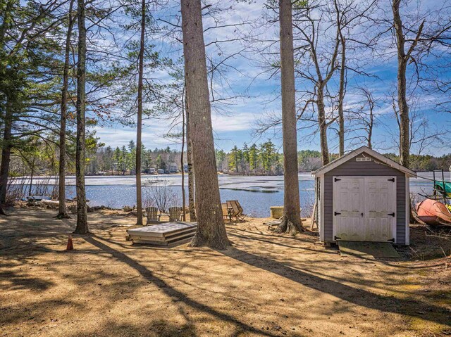 view of yard with a water view, a storage unit, and an outdoor structure