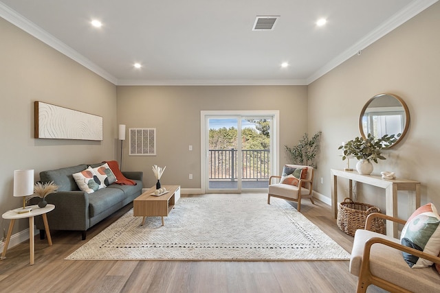 living room featuring visible vents, baseboards, ornamental molding, wood finished floors, and recessed lighting