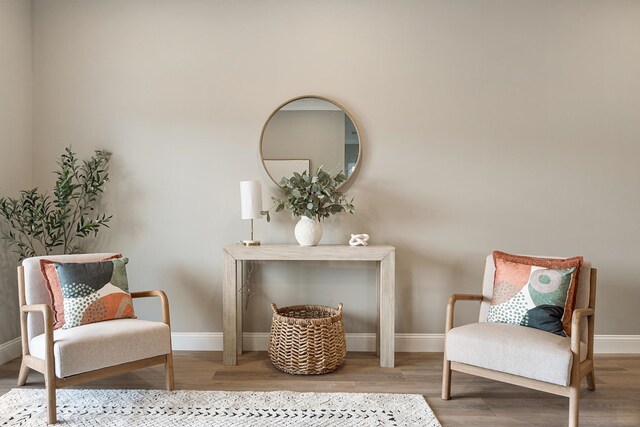 living area with baseboards and wood finished floors