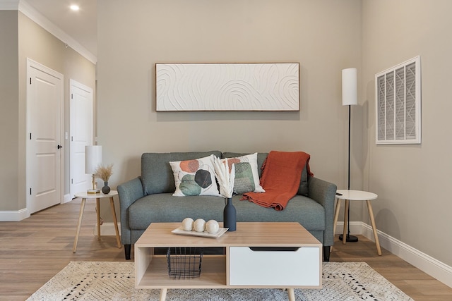 living area featuring baseboards, visible vents, and wood finished floors