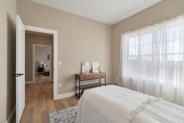 bedroom featuring baseboards and light wood-style floors