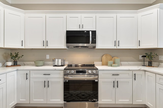 kitchen with white cabinets, light stone countertops, and stainless steel appliances