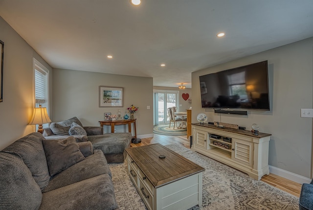 living room featuring light wood-style flooring, baseboards, and recessed lighting