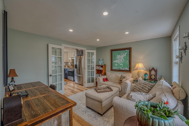living room featuring french doors, recessed lighting, and light wood-type flooring