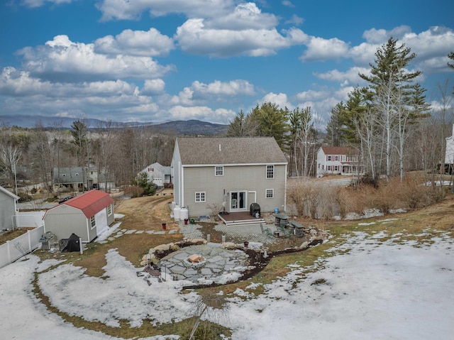 rear view of house with a mountain view and fence