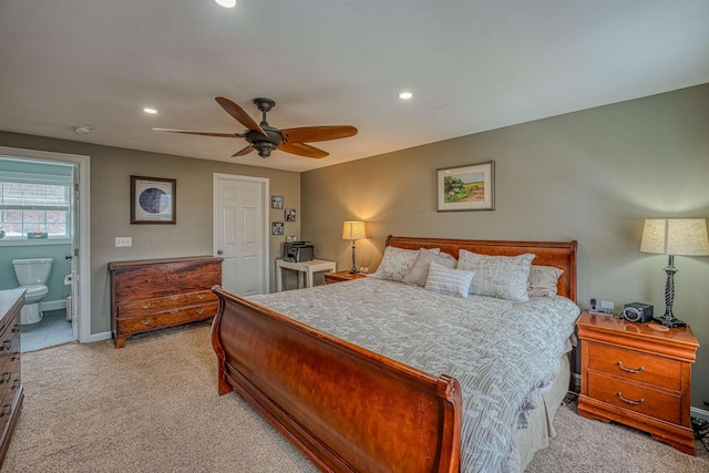 bedroom with light colored carpet, recessed lighting, baseboards, ensuite bath, and a ceiling fan