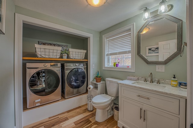 bathroom featuring independent washer and dryer, vanity, toilet, and wood finished floors