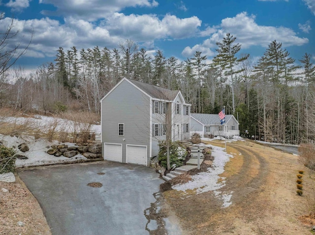view of property exterior with a garage and aphalt driveway