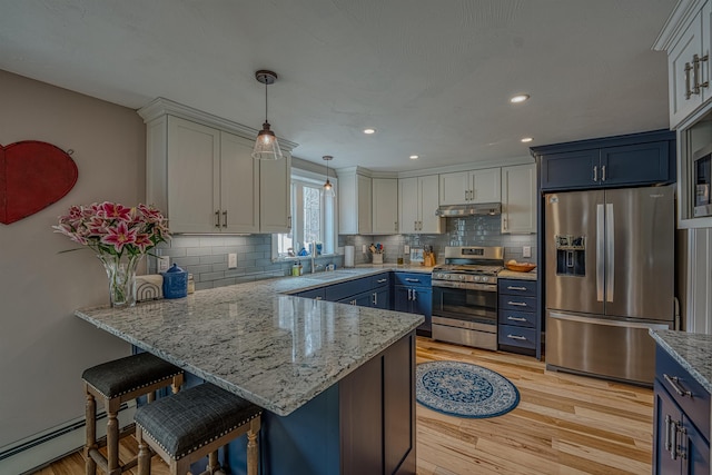 kitchen featuring blue cabinetry, a peninsula, stainless steel appliances, and under cabinet range hood