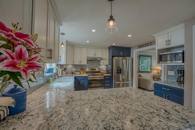 kitchen with tasteful backsplash, under cabinet range hood, a sink, light stone countertops, and appliances with stainless steel finishes