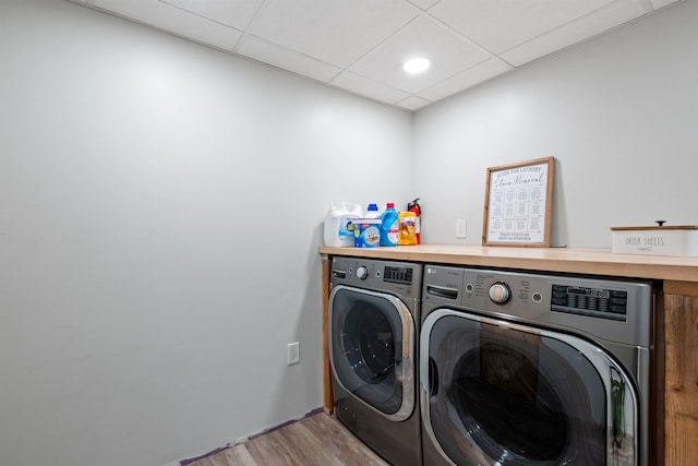 laundry room featuring washer and clothes dryer and wood finished floors