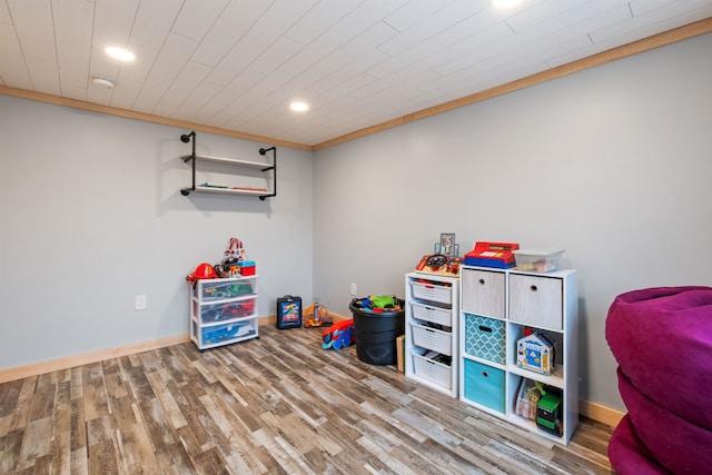 recreation room with baseboards, wood finished floors, and recessed lighting