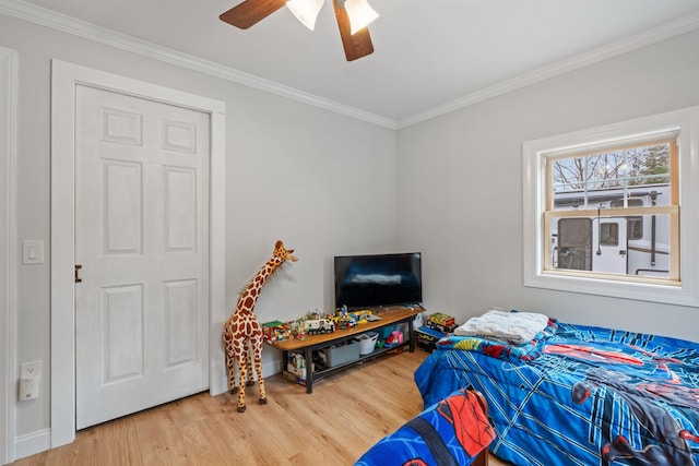 bedroom with ornamental molding, ceiling fan, and wood finished floors