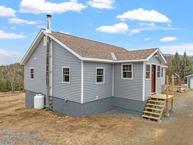 rear view of property featuring roof with shingles