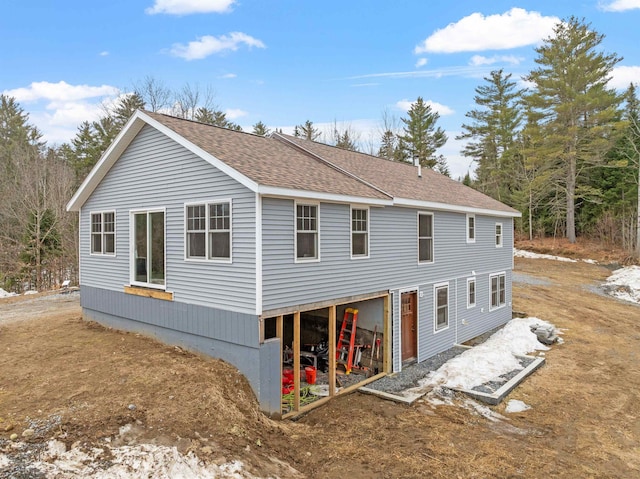 back of property featuring roof with shingles