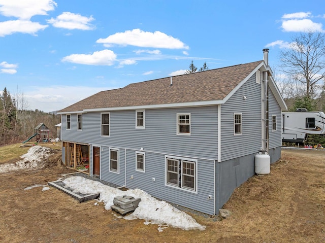 rear view of property with roof with shingles