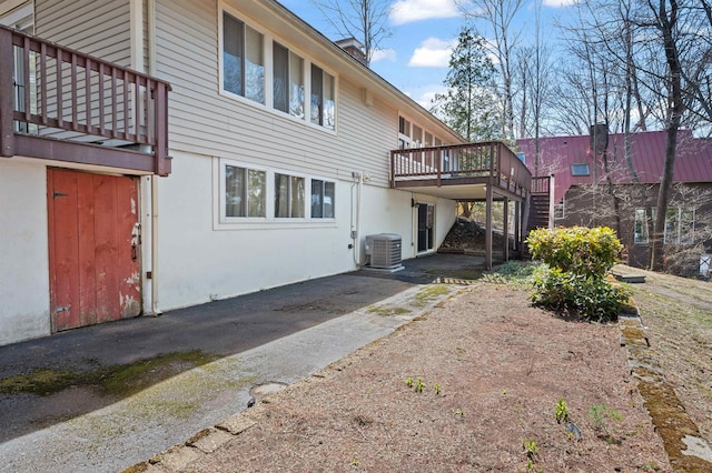 back of house featuring stairway, central AC unit, stucco siding, a patio area, and a deck