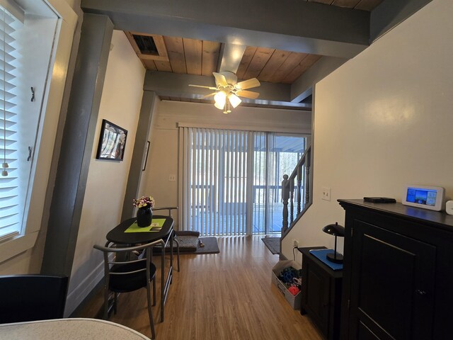 interior space featuring a ceiling fan, wood finished floors, wood ceiling, beamed ceiling, and visible vents